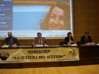 En la imagen y, de izquierda a derecha, Francisco Luis Pérez, presidente de la Junta Municipal del Distrito Triana del Ayuntamiento de Sevilla; Vicente Guzmán, rector de la UPO; Carmen Belinchón, directora general de Justicia Juvenil y Cooperación de la Junta de Andalucía y Javier Alés, director de las jornadas. En la imagen de fondo, Rosario Valpuesta.