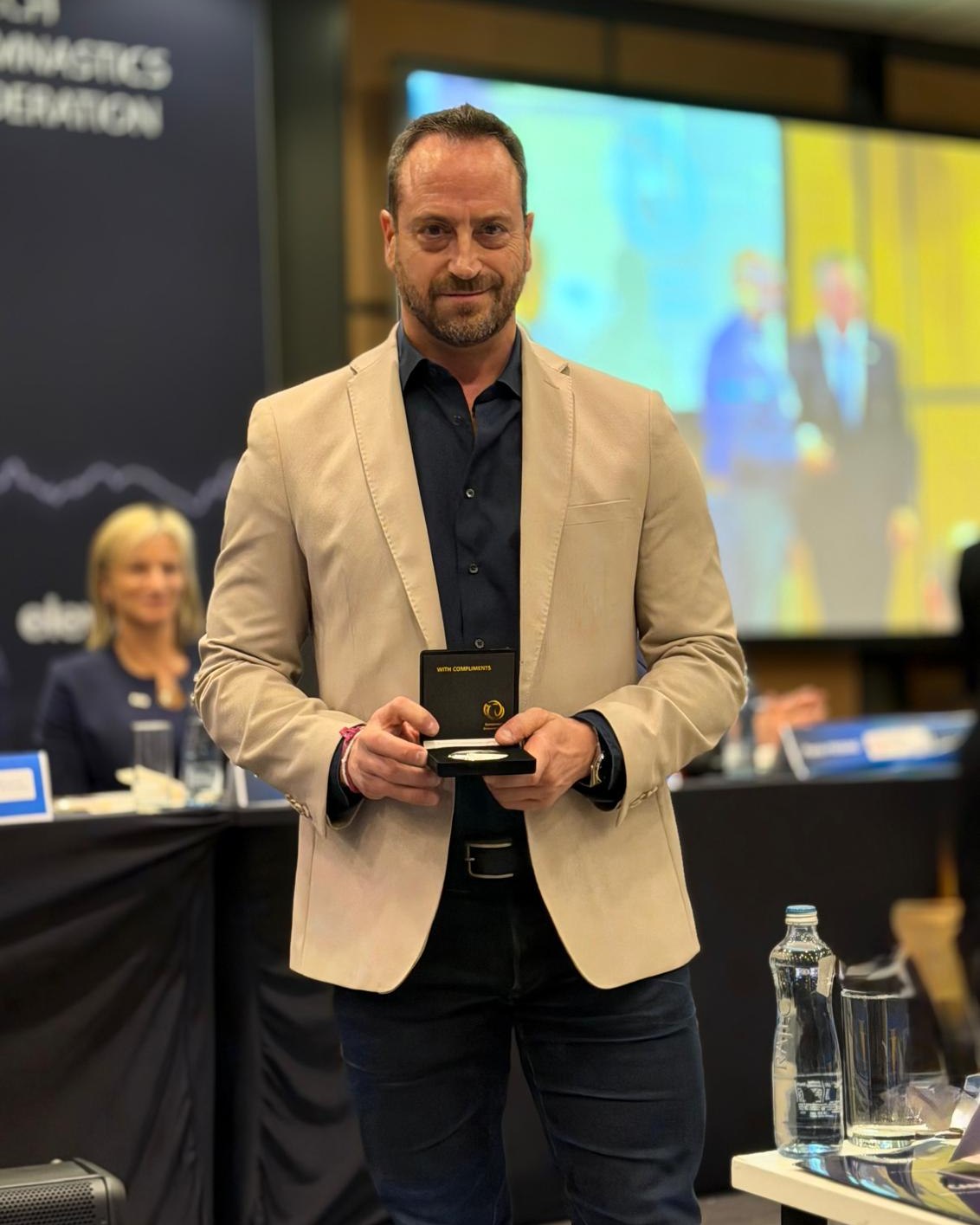 🔝 🏅Queremos felicitar con orgullo a nuestro profesor de la Facultad de Ciencias del Deporte, Juan Antonio León-Prados, por un reconocimiento más que merecido 👏

Ha sido distinguido con la Medalla de Plata al Mérito durante el Congreso de European Gymnastics celebrado en Praga, en reconocimiento a su labor como vicepresidente del Comité Técnico de Gimnasia Acrobática durante dos ciclos olímpicos (2018–2025).

Durante este periodo, ha participado en la gestión técnica y organizativa de grandes citas internacionales de la disciplina, incluyendo cuatro Campeonatos de Europa de Gimnasia Acrobática (2019, 2021, 2024 y 2026) y dos ediciones de los Juegos Europeos (2015 y 2019).

Su trabajo también ha impulsado la innovación en la gestión de competición y en el control del rendimiento de los jueces. En concreto, ha desarrollado dos herramientas pioneras para mejorar la transparencia, la trazabilidad y el cumplimiento normativo: ACRODraw y EJD (Electronic Judge Draw), software para el sorteo electrónico de jueces conforme a los requisitos oficiales; y ACROAJIR (Automatic Judges Individual Report), un sistema de evaluación del desempeño de jueces con informes automáticos para el seguimiento técnico.

En el ámbito internacional, fue elegido vicepresidente del Comité Técnico de Gimnasia Acrobática de la Federación Internacional de Gimnasia (World Gymnastics) en octubre de 2024, cargo que ejerce desde enero de 2025. Además, ha participado como oficial en los Juegos Mundiales de Chengdu (China, 2025), reforzando la presencia académica y científica española en los órganos técnicos internacionales.

Este reconocimiento pone en valor el talento, la investigación y la proyección internacional de nuestro profesorado. 

¡Enhorabuena Juan! 👏

#LaOlavideEresTú #TalentoUPO #Deporte #GimnasiaAcrobática