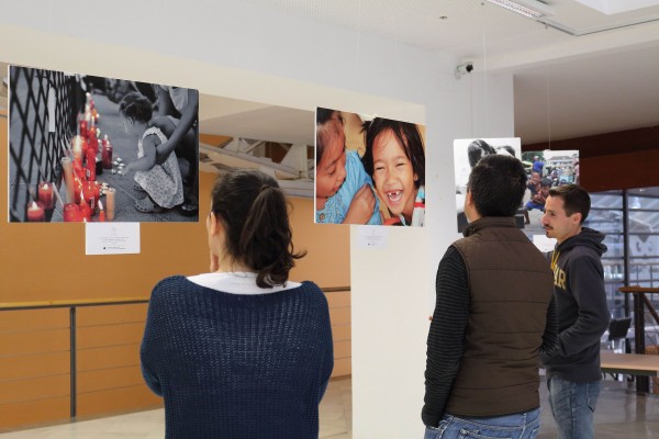 estudiantes contemplan las fotografías en la Biblioteca