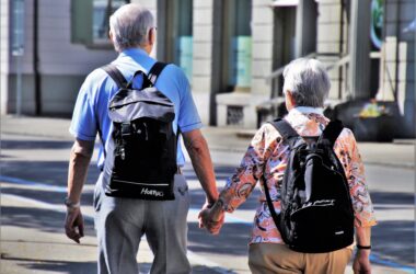 Una pareja de personas mayores pasean por una calle