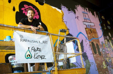 Rafael López ante el mural que ha diseñado para la entrada del campus UPO