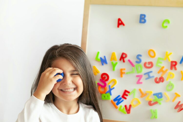 Niña ante pizarra con letras