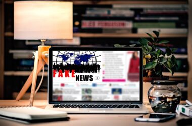 Pantalla de un portátil sobre un escritorio con el texto 'Fake News'