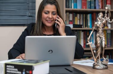 Abogada consulta su ordenador en su despacho mientras habla por teléfono