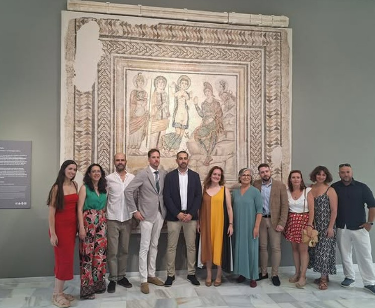 Foto del equipo del museo, de Comintrad y de Amma, posando ante el Mosaico de Paris durante la inauguración.
