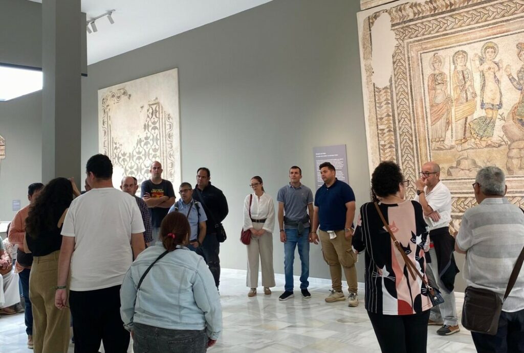 Esta imagen muestra al grupo de visitantes escuchando a Ana Medina frente al Mosaico del Juicio de Paris