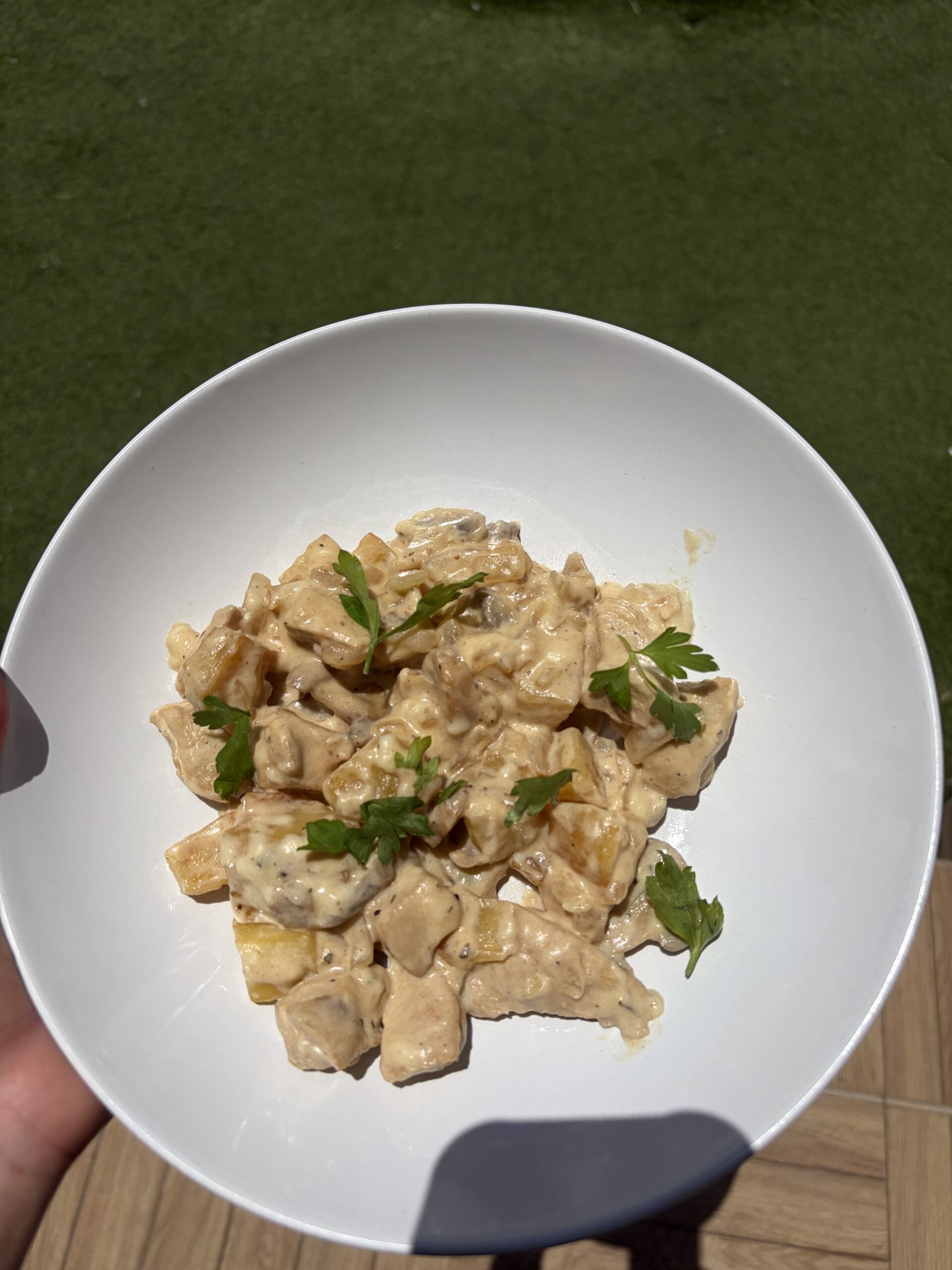 Pollo con crema, patatas, cebolla y perejil.